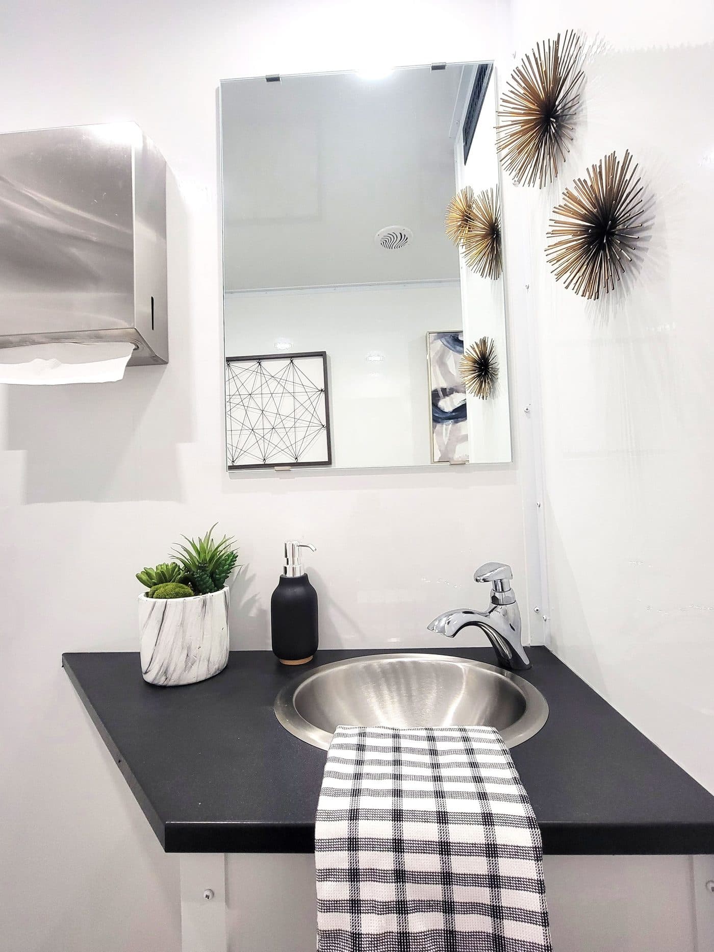 Men's interior of a two-station ECO luxury restroom trailer with stainless fixtures and LED lighting